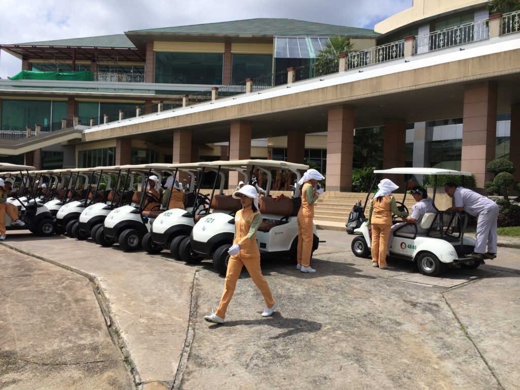 Caddies and golf carts parked in front of the club house.